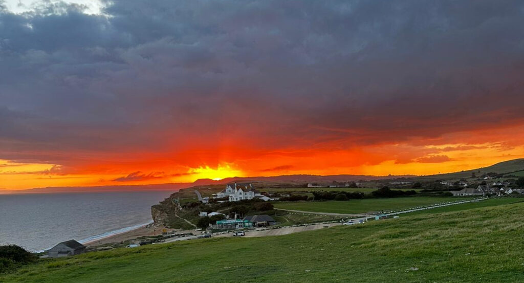 Sunset showing 'our' Burton Bradstock Bungalow at the coast. I may be in the far field walking the dog. Photo by Ruby with Tom.